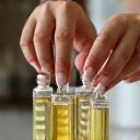 Hands carefully pouring a liquid into small bottles